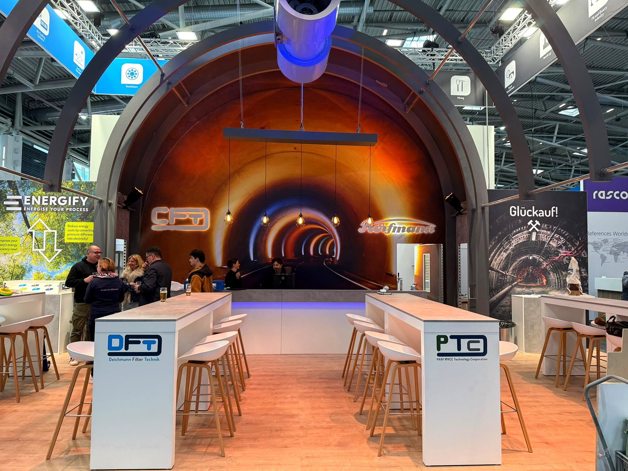 serfair Messebau — Kongress-Stand im Aufbau, warmes Arbeitslicht in der Halle